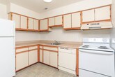 Located at 2851 Glenview Ct in Port Huron, Michigan, this single-floor unit offers a practical and comfortable layout designed for everyday living. The living area is generously sized, finished with neutral carpet underfoot and a sliding glass door that opens to a private deck overlooking mature trees, allowing natural light to fill the space throughout the day. Vertical blinds provide privacy while maintaining the connection to the outdoors.

The kitchen is efficiently arranged in an L-shaped configuration, featuring white cabinetry with warm wood trim accents, light countertops, a stainless steel sink, and white appliances including a refrigerator, electric range, and dishwasher. Tile flooring completes the functional workspace.

Multiple carpeted bedrooms offer quiet retreats, each brightened by windows with views of surrounding greenery. One bedroom provides direct sliding door access to the deck, adding a versatile indoor-outdoor connection.

The bathrooms are clean and straightforward — one full bath includes a tiled tub-and-shower combination with a classic mosaic tile floor, while a second bathroom provides a half-bath setup. A dedicated utility/laundry room houses washer hookups and an electrical panel, rounding out the practical amenities of this well-organized single-level home.