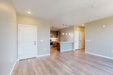 Located at 17607 East 61st Avenue in Denver, CO, this well-appointed one-bedroom, one-bathroom residence offers a thoughtfully designed single-floor layout with modern finishes throughout. The open-concept living and dining area is anchored by wide-plank hardwood-style flooring, neutral warm-toned walls, and a sliding glass door that opens onto a private balcony with outdoor views, filling the space with natural light.

The kitchen is a standout feature, showcasing rich dark wood cabinetry extending to the ceiling, stainless steel appliances including a French door refrigerator, electric range, and built-in microwave, complemented by white quartz countertops, a herringbone tile backsplash, and a peninsula island with pendant lighting and an undermount sink — ideal for both cooking and entertaining.

The bedroom offers plush carpeting, a ceiling fan, two windows for natural light, and built-in shelving for added storage. Two closets provide generous storage capacity. The full bathroom is finished with large-format tile flooring, a wood-tone vanity with white countertop, and a tub-shower combination with clean white tile surround. Additional spaces include a pantry, hallway, and utility room, rounding out this efficiently designed Denver residence.
