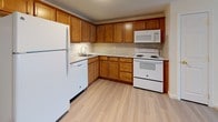 Located at 2 Lonvale in Amesbury, Massachusetts, this single-floor residence offers a well-organized layout across several distinct living areas. The kitchen is equipped with warm-toned wood cabinetry, granite-look countertops, and a full suite of white GE appliances including a refrigerator, dishwasher, electric range, and over-the-range microwave. Light hardwood-style flooring runs throughout the kitchen, adding a clean, contemporary feel. The living areas feature neutral wall-to-wall carpeting that creates a comfortable and cohesive atmosphere. Baseboard heating units are present throughout the home, ensuring efficient climate control during colder months. The spacious main living room is open and versatile, with a door providing direct access to the entryway. A secondary carpeted room, visible from the main living space, offers additional flexibility and benefits from natural light via a window overlooking the surrounding community. The full bathroom is finished in a clean, all-white palette, featuring a single-sink vanity with a mirrored medicine cabinet, a combined shower and soaking tub, and hardwood-style flooring. The overall design of this residence prioritizes functionality and ease of living, with a neutral color scheme that provides a welcoming, move-in-ready environment.