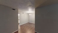Located at 605 Catalina Dr in Waco, Texas, this single-story home offers a practical and functional layout spread across a well-defined floor plan. Throughout the interior, dark hardwood-style flooring provides a consistent and grounding aesthetic, complemented by white baseboards and neutral-toned walls.

The main living and dining areas are open and well-lit, with the dining space highlighted by a classic chandelier overhead. Textured popcorn ceilings are found throughout the home, adding a distinctive character to each room. HVAC vents are integrated into the walls and ceilings, ensuring climate control across the space.

The kitchen features white cabinetry with decorative paneled doors, gray laminate countertops, a white electric range, and an over-the-range microwave, offering ample storage and counter space in a galley-style configuration.

The bedrooms are generously sized, each receiving natural light through blinded windows, and are equipped with ceiling fans for added comfort. The bathroom is well-appointed with a tiled tub and shower surround in a neutral stone-like finish, a white vanity with stone countertop, and wood-look flooring that ties cohesively to the rest of the home.