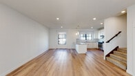 This well-appointed 3-floor home offers a thoughtfully designed layout with modern finishes throughout. The entry level features light hardwood flooring, a staircase with dark-toned railings, and access to multiple rooms. The open-concept kitchen and living area is a standout, boasting wide-plank hardwood floors, recessed lighting, and abundant natural light from multiple windows. The kitchen is fully equipped with white shaker cabinetry, granite countertops, a subway tile backsplash, a center island, and a full suite of stainless steel appliances including a gas range, over-the-range microwave, dishwasher, and side-by-side refrigerator. Bedrooms are finished with plush carpeting, ceiling fans, and generous closet space, including a large walk-in closet outfitted with wire shelving systems for organized storage. Natural light filters through well-placed windows, enhancing the bright and airy atmosphere throughout. The bathroom features a dual-sink vanity with granite countertops, a large mirror, and a glass-enclosed tiled shower, all finished with clean, contemporary hardware. The multi-level layout provides excellent separation of living and private spaces, making this home as functional as it is visually cohesive.