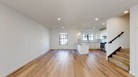 This well-appointed 3-floor home offers a thoughtfully designed layout with modern finishes throughout. The entry level features light hardwood flooring, a staircase with dark-toned railings, and access to multiple rooms. The open-concept kitchen and living area is a standout, boasting wide-plank hardwood floors, recessed lighting, and abundant natural light from multiple windows. The kitchen is fully equipped with white shaker cabinetry, granite countertops, a subway tile backsplash, a center island, and a full suite of stainless steel appliances including a gas range, over-the-range microwave, dishwasher, and side-by-side refrigerator. Bedrooms are finished with plush carpeting, ceiling fans, and generous closet space, including a large walk-in closet outfitted with wire shelving systems for organized storage. Natural light filters through well-placed windows, enhancing the bright and airy atmosphere throughout. The bathroom features a dual-sink vanity with granite countertops, a large mirror, and a glass-enclosed tiled shower, all finished with clean, contemporary hardware. The multi-level layout provides excellent separation of living and private spaces, making this home as functional as it is visually cohesive.