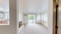 Located at 12623 E Broadway Ave in Spokane Valley, WA, this single-floor, 3-bedroom, 1-bathroom unit offers a practical and well-organized layout. The kitchen is equipped with light wood cabinetry, white appliances including an electric range and dishwasher, a double-basin sink beneath a window that brings in natural light, and a peninsula counter with a breakfast bar that flows into the adjacent living area. The flooring transitions from durable wood-look vinyl in the kitchen to plush carpet throughout the rest of the unit. All three bedrooms are carpeted and feature neutral wall tones, ceiling light fixtures, and baseboard heating. Two of the bedrooms benefit from windows with outdoor views of the surrounding greenery, while the primary bedroom includes a wide sliding-door closet offering generous storage. An additional dedicated closet provides further organization options. The bathroom is clean and functional, featuring a full tub-shower combo with a curtain rod, wood-look vinyl flooring, and a wall-mounted towel bar. The overall aesthetic is bright, neutral, and move-in ready, making this a straightforward and efficient living space.