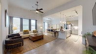 This two-story residence at 764 Westinghouse Rd in Georgetown, Texas offers a thoughtfully designed open-concept layout that promotes a seamless flow between living spaces. The main living area commands attention with soaring ceilings and a ceiling fan overhead, creating an airy, expansive atmosphere. Light-toned wood-style flooring runs throughout, unifying the space cohesively.

The kitchen is a standout feature, equipped with sleek grey cabinetry, stainless steel appliances, a white quartz waterfall island with bar seating, pendant lighting, and a classic subway tile backsplash. It connects effortlessly to the dining area, which benefits from natural light through multiple windows. A separate formal dining space provides additional room for entertaining.

The primary bedroom is generously proportioned, featuring bay windows that invite natural light and walk-in closet access. Its en-suite bathroom includes dual undermount sinks with a white quartz vanity, a soaking tub with tiled surround, and a separate shower. Additional bedrooms offer closet storage and comfortable proportions. A secondary living area on one of the levels provides flexible use as a lounge or office, completing this well-rounded, modern home.