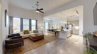 This two-story residence at 764 Westinghouse Rd in Georgetown, Texas offers a thoughtfully designed open-concept layout that promotes a seamless flow between living spaces. The main living area commands attention with soaring ceilings and a ceiling fan overhead, creating an airy, expansive atmosphere. Light-toned wood-style flooring runs throughout, unifying the space cohesively.

The kitchen is a standout feature, equipped with sleek grey cabinetry, stainless steel appliances, a white quartz waterfall island with bar seating, pendant lighting, and a classic subway tile backsplash. It connects effortlessly to the dining area, which benefits from natural light through multiple windows. A separate formal dining space provides additional room for entertaining.

The primary bedroom is generously proportioned, featuring bay windows that invite natural light and walk-in closet access. Its en-suite bathroom includes dual undermount sinks with a white quartz vanity, a soaking tub with tiled surround, and a separate shower. Additional bedrooms offer closet storage and comfortable proportions. A secondary living area on one of the levels provides flexible use as a lounge or office, completing this well-rounded, modern home.