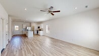 Located at 1423 Honeysuckle St in Lowell, Arkansas, this two-story home offers a clean, modern design with a bright and airy aesthetic throughout. The main floor is anchored by a generous open-concept living and kitchen area, where light hardwood flooring, recessed lighting, and a ceiling fan create a welcoming atmosphere. Vaulted ceilings in the living space add a sense of openness, flowing seamlessly into the kitchen. The kitchen features white shaker cabinetry, granite countertops, stainless steel appliances, a center island, and a convenient walk-in pantry. A dedicated laundry room with full-size washer and dryer hookups adds everyday practicality to the main level. The primary bedroom is a comfortable retreat with a ceiling fan, large windows, and an en-suite bathroom showcasing a granite vanity and a glass-enclosed walk-in shower. Two additional bedrooms, each with hardwood floors and natural light, are well-sized and versatile. The additional bathrooms include a tub-shower combo with built-in shelving and granite-topped vanities. Hallways connecting each area maintain the home's cohesive, neutral palette. The upper floor provides a more intimate setting, ideal for secondary bedrooms or flexible use. Throughout, the home presents a fresh, move-in-ready feel with consistent finishes and thoughtful layout.