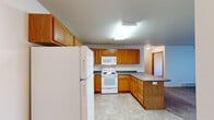 This single-floor unit offers a practical and functional layout designed to maximize usability across its living spaces. The kitchen is a standout feature, outfitted with warm oak cabinetry offering abundant upper and lower storage, dark laminate countertops, white appliances including a range, built-in microwave, refrigerator, and dishwasher, and durable tile flooring. A peninsula counter extends the workspace and provides a natural transition into the adjacent living and dining area.

The living area is carpeted and features a sliding glass door fitted with vertical blinds, opening to a balcony and allowing natural light to fill the space. A wall-mounted air conditioning unit and baseboard heating ensure year-round comfort. Neutral wall tones throughout lend a clean, move-in-ready feel.

The bedrooms are carpeted with baseboard heating and natural light from windows with blinds. Closet space is generous, including a walk-in closet with wire shelving systems for organized storage.

The bathroom includes tile flooring, an oak vanity with a dark countertop, a sink, toilet, and a full bathtub with a shower curtain rod. The textured ceilings are consistent throughout, adding a classic residential character to the overall space.