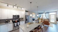 Located at 351 E Dry Creek Rd in Littleton, Colorado, this single-story residence offers a thoughtfully designed layout with contemporary finishes and a cohesive, modern aesthetic throughout. The open-concept kitchen serves as a central feature of the home, showcasing granite countertops, white shaker-style cabinetry, a herringbone tile backsplash, and a full suite of stainless steel appliances including a French door refrigerator, electric range, and built-in microwave. A large kitchen island with an undermount sink and pendant lighting provides both prep space and casual seating, flowing naturally into the living and dining areas. The living room benefits from large windows with floor-to-ceiling drapes that invite natural light and offer outdoor views, complemented by wood-style flooring and a ceiling fan. Multiple bedrooms feature plush carpeting, ceiling fans, and well-sized windows that brighten each room. The bathrooms are finished with granite-topped vanities, large-format tile flooring, and glass-enclosed showers, maintaining the home's consistent attention to detail. Neutral wall tones and clean white trim tie the interior together, creating a bright and welcoming atmosphere throughout.