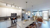 Located at 351 E Dry Creek Rd in Littleton, Colorado, this single-story residence offers a thoughtfully designed layout with contemporary finishes and a cohesive, modern aesthetic throughout. The open-concept kitchen serves as a central feature of the home, showcasing granite countertops, white shaker-style cabinetry, a herringbone tile backsplash, and a full suite of stainless steel appliances including a French door refrigerator, electric range, and built-in microwave. A large kitchen island with an undermount sink and pendant lighting provides both prep space and casual seating, flowing naturally into the living and dining areas. The living room benefits from large windows with floor-to-ceiling drapes that invite natural light and offer outdoor views, complemented by wood-style flooring and a ceiling fan. Multiple bedrooms feature plush carpeting, ceiling fans, and well-sized windows that brighten each room. The bathrooms are finished with granite-topped vanities, large-format tile flooring, and glass-enclosed showers, maintaining the home's consistent attention to detail. Neutral wall tones and clean white trim tie the interior together, creating a bright and welcoming atmosphere throughout.