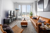 Located on the 14th floor at 299 Campbell Ave in Toronto's vibrant Junction neighbourhood, this 2-bedroom, 2-bathroom unit offers a well-designed layout with modern finishes throughout. Light wood flooring runs continuously across the single level, complementing the bright, neutral colour palette.

The entry hallway features a graceful arched mirror and opens into a sun-filled living room anchored by floor-to-ceiling sliding glass doors that lead to a private balcony, offering sweeping views of the Toronto skyline and surrounding greenery. Natural light floods the space throughout the day.

The primary bedroom is generously proportioned, boasting its own access to the balcony through full-height glass doors with roller blinds, providing abundant natural light and panoramic city views. It includes a mirrored sliding-door closet for ample storage. The second bedroom is well-sized with its own closet and large wall space.

Both bathrooms are finished in clean, contemporary white with light wood cabinetry. One features a glass-enclosed walk-in shower, while the other offers a full soaker tub with overhead shower — both appointed with sleek chrome fixtures.

The overall ambiance is calm, modern, and airy, making this a well-appointed urban retreat in one of Toronto's most sought-after west-end neighbourhoods.