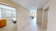 This contemporary apartment offers 1090 square feet of thoughtfully designed living space. The open-concept layout creates a seamless flow between the living room, dining area, and kitchen, ideal for both everyday living and entertaining. The kitchen boasts sleek white cabinetry, stainless steel appliances, and granite countertops, creating a modern and functional cooking space.

The apartment features three bedrooms, including a spacious 170 square foot primary bedroom. All bedrooms are equipped with ceiling fans and large windows, allowing for natural light and air circulation. The two bathrooms are well-appointed, with one featuring a luxurious walk-in shower with marble-like tiling.

Throughout the apartment, you'll find light-colored wood-look flooring, creating a bright and airy atmosphere. The living areas are adorned with stylish furniture and decor, including a comfortable gray sofa and accent chairs. Large windows in the main living area offer views and ample natural light.

Storage is abundant, with a walk-in closet featuring multiple shelving units. The apartment also includes modern amenities such as recessed lighting, window blinds, and in-unit laundry facilities. The overall design aesthetic is clean and minimalist, with a neutral color palette that allows for personal touches and decorating flexibility.