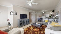 Located in Derby, Kansas, this single-floor, three-bedroom, two-bathroom home offers a thoughtfully designed layout that maximizes comfort and functionality. The open-concept living and dining area serves as the heart of the home, featuring crown molding, neutral-toned walls, plush carpeting, and a ceiling fan overhead. Natural light flows in through large windows fitted with blinds, creating a bright and welcoming atmosphere. The kitchen is well-appointed with white cabinetry, dark countertops, a breakfast bar with seating, black appliances, and an adjacent dining area — ideal for both casual meals and entertaining. The spacious primary bedroom features its own dedicated closet with built-in shelving, a ceiling fan, and a window allowing for natural light. The additional bedrooms are generously sized, each with ceiling fans and windows. The two bathrooms include a tub-shower combo with sliding glass doors and wood-style flooring. A dedicated laundry room houses a full-size washer and dryer along with wire shelving for storage. Throughout the home, the consistent use of light, neutral tones and carpet creates a cohesive, comfortable living environment.
