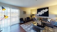 Located at 95 W Squantum St in Quincy, Massachusetts, this well-appointed single-floor residence offers a thoughtfully designed layout that balances comfort and functionality. The living room serves as the heart of the home, highlighted by rich hardwood flooring, a distinctive painted brick accent wall, and a large sliding glass door that floods the space with natural light while offering outdoor views. The dining area flows seamlessly from the entry, featuring the same warm hardwood floors and a closeted storage space nearby, creating a welcoming and organized entryway. The kitchen is outfitted with crisp white cabinetry, dark stone countertops, a classic subway tile backsplash, and stainless steel appliances including a range and over-the-range microwave, providing a clean and efficient cooking environment. The bedroom is a comfortable retreat with plush carpeting, a ceiling fan with light fixture, natural light from a window with outdoor views, and a generously sized closet with built-in shelving for ample storage. The full bathroom features white subway tile surround, a combined tub and shower, a framed vanity mirror, and warm overhead lighting, all complemented by hardwood-style flooring for a cohesive finish throughout the residence.