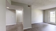 Located at 500 Windsor Green Blvd in Goodlettsville, TN, this one-bedroom, one-bathroom unit offers a practical and well-appointed layout across a single floor. The open-concept living room and kitchen area is finished with durable wood-look vinyl plank flooring and neutral gray walls, creating a clean, modern aesthetic. French doors lead from the living room to a private balcony, allowing natural light to fill the space and providing pleasant outdoor views. The kitchen is thoughtfully designed with rich dark cabinetry, marble-pattern countertops, black appliances including a range, refrigerator, and dishwasher, and light tile-style flooring — a striking contrast that gives the space a contemporary feel. The bedroom offers comfortable carpeting underfoot and benefits from a natural light source via a window with blinds. It connects directly to a dedicated closet and provides easy access to the full bathroom. The bathroom features a combined tub and shower unit with clean white surroundings, light plank flooring, and chrome fixtures. Textured ceilings are consistent throughout the unit. The overall layout is efficient and cohesive, making practical use of every area while maintaining a neutral, move-in-ready aesthetic throughout.