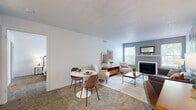 Located at 100 Town Walk Dr in New Haven, CT, this single-floor residence offers a thoughtfully laid-out living space with a clean, contemporary aesthetic throughout. The open living area serves as the heart of the home, centered around a wood-burning fireplace framed by a classic white mantel and flanked by windows that invite natural light into the room. Soft carpet underfoot and neutral wall tones create a warm, welcoming ambiance, while a dedicated dining area connects seamlessly to the living space. The kitchen features white shaker-style cabinetry, a white tile subway backsplash, light countertops, and stainless steel appliances including a gas range and refrigerator, all set on wood-look flooring. The bedroom is generously proportioned with plush carpeting, large sliding glass doors that open to an outdoor view, and access to a spacious walk-in closet outfitted with wire shelving systems for ample organization. The full bathroom is finished with wood-look flooring, white tile surrounding the tub-shower combination, and a white vanity with mirror. A versatile nook near the entry provides additional flexible living or workspace. Together, these features offer a well-rounded, functional, and comfortable living environment in the New Haven area.