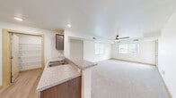 Located at 810 Seventh Ave NE in Isanti, Minnesota, this single-floor, one-bedroom, one-bathroom unit offers a practical and well-appointed layout. The open-concept kitchen and living area form the heart of the home, creating a seamless flow between cooking and relaxing spaces. The kitchen is equipped with stainless steel appliances — including a refrigerator, range, and dishwasher — complemented by rich dark-brown cabinetry, granite-look countertops, and a functional peninsula with a double sink. Light wood-style flooring runs throughout the kitchen, while a dedicated pantry provides ample storage. The living area transitions to plush carpet underfoot, with large windows that invite natural light and a ceiling fan overhead to ensure year-round comfort. The bedroom is generously sized, featuring carpeted floors, a window with exterior views, and a sliding-door closet. An additional closet offers further storage convenience. The full bathroom includes a dark-wood vanity with a wide mirror, a single-sink countertop, and a tub-shower combination. Clean, neutral finishes and recessed lighting throughout lend the space a bright, move-in-ready feel.