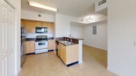 Located at 5225 Northwest 29th Avenue in Miami, FL, this two-bedroom, one-bathroom residence offers a well-organized single-floor layout designed for comfortable everyday living. Light-toned ceramic tile flooring runs consistently throughout the space, contributing to a clean, cohesive aesthetic.

The open-concept living and dining area is bright and airy, with a ceiling fan overhead and sliding glass doors that lead to a private balcony, allowing natural light to flow through the space. The kitchen features warm wood-tone cabinetry, dark granite-style countertops, a peninsula with a double sink, and a full suite of appliances including a range, built-in microwave, and refrigerator — making it both practical and visually connected to the main living area.

Both bedrooms are well-proportioned, each equipped with ceiling fans, natural light from windows with blinds, and generous closet space via bi-fold doors. The primary bedroom includes a notably spacious closet configuration. A hallway lined with multiple closets provides exceptional storage throughout.

The bathroom is fully equipped with a tub-shower combination, accessibility grab bars, a granite-topped vanity with wood cabinetry, and tile surround. A dedicated laundry area and in-unit electrical panel add to the home's overall functionality. The space is thoughtfully designed to maximize utility within a compact Miami footprint.