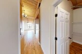 Located at 717 N Clinton St in Syracuse, NY, this 2-bedroom, 3-bathroom unit showcases a distinctive loft-inspired aesthetic rooted in industrial character and warm natural materials. Throughout the space, polished hardwood floors and striking exposed wood plank ceilings with heavy timber beams create a cohesive, inviting atmosphere. Large multi-pane windows flood each room with abundant natural light, enhancing the open, airy feel.

A long hallway connects the main living areas, leading to a generously sized living room anchored by a ceiling fan and chandelier lighting. The kitchen is well-appointed with warm honey-toned wood cabinetry, granite-style countertops, and a full suite of stainless steel appliances including a refrigerator, dishwasher, range, and microwave. Exposed ductwork on the ceiling adds to the industrial charm.

The two bedrooms are bright and spacious, each benefiting from large windows and the signature wood ceiling detail, with exposed timber columns adding architectural interest. Five closets provide ample storage throughout the unit. The three bathrooms feature tile flooring, wood vanities with solid-surface countertops, and clean, functional layouts. This unit offers a compelling blend of historic character and modern convenience.
