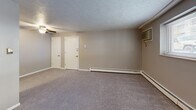Located at 600 Stevens Dr in Pittsburgh, PA, this three-bedroom, one-bathroom unit offers a practical and efficient single-floor layout. The spacious primary bedroom is notably generous in size, featuring a wall-mounted air conditioning unit, baseboard heating, and a window that brings in natural light with views of the surrounding area. Two additional bedrooms each include ceiling fans with light fixtures, carpeted flooring, baseboard heating, and windows with blinds, providing comfortable and functional living spaces. Two closets offer ample storage throughout the unit. The kitchen is equipped with warm wood-toned cabinetry, a white electric range, and a sink with countertop workspace, all set on hard surface flooring. The full bathroom features a shower-tub combination with clean white surrounds and yellow accent tile detailing. The main living area is open and carpeted, with textured ceilings throughout the unit, dual closet access, a ceiling fan, and baseboard heating supplemented by a wall A/C unit. Natural light filters through multiple windows across the unit, contributing to a bright and livable atmosphere throughout.