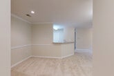 Located at 906 Beacon Square Ct in Gaithersburg, MD, this single-floor, 2-bedroom, 2-bathroom residence offers a well-organized and functional layout with a warm, neutral aesthetic throughout. The open-concept living and kitchen area serves as the heart of the home, where plush carpeting flows through the living space and a peninsula breakfast bar connects seamlessly to the kitchen. The kitchen is equipped with warm wood-toned cabinetry, ample counter space, and white appliances including a gas range, dishwasher, and built-in microwave, along with hardwood-style flooring. Crown molding and recessed lighting add a polished touch to the main living area. The generously sized primary bedroom features a ceiling fan, a large window that fills the room with natural light and views of lush surrounding trees, and direct access to a private outdoor area via sliding glass doors fitted with vertical blinds. The second bedroom is equally well-proportioned with its own window and soft carpeting. Both bathrooms are finished with tile flooring, full tub/shower combos, and wood-toned vanity cabinetry. Additional conveniences include three closets, a pantry, and a dedicated utility room, ensuring excellent storage throughout.