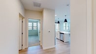 Located at 3001 Community Way in Menasha, WI, this thoughtfully designed two-bedroom, two-bathroom residence offers a clean, modern aesthetic throughout its well-organized single-floor layout. Light hardwood flooring flows through the main living areas, complemented by neutral wall tones that create a bright, welcoming atmosphere.

The kitchen is a standout feature, outfitted with crisp white shaker cabinetry, a marble-style tile backsplash, stainless steel appliances including a refrigerator, range, microwave, and dishwasher, and a central island with a sink. Stylish black pendant lights accent the space overhead. A large sliding glass door connects the kitchen and living area to a private balcony, offering open outdoor views of the surrounding neighborhood.

The spacious living room benefits from an abundance of natural light streaming through multiple large windows with blinds, and continues the warm hardwood flooring. The generously sized primary bedroom features its own hardwood floors and ample natural light, while the second bedroom is finished with plush carpet and a window with outdoor views.

Both bathrooms are clean and functional, with one featuring a full soaking tub and shower surround with built-in shelving. A dedicated in-unit laundry room houses a stacked washer and dryer, adding everyday convenience to this well-rounded residence.