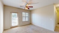 Located at 601 Giddings Court in Augusta, Georgia, this single-floor residence offers a practical and comfortable layout across two bedrooms and two bathrooms. The living area is carpeted and bathed in natural light, with a ceiling fan overhead and a glass door providing direct access to the outdoors. Crown molding accents add a polished touch to the main living spaces.

The kitchen features a peninsula with a dark countertop, rich brown cabinetry, track lighting, and black appliances including a range, microwave, and refrigerator. Wood-look flooring in the kitchen ties seamlessly into the carpeted living area.

The primary bedroom is generously sized, with carpet flooring, a ceiling fan, and a glass door leading to an outdoor area. The second bedroom is also carpeted, bright, and well-proportioned, featuring a ceiling fan and a large window overlooking greenery. Both bedrooms include dedicated closets for ample storage.

The bathrooms are clean and functional, with one featuring a full tub-shower combo finished in white tile with built-in shelving niches and brushed nickel fixtures. A dedicated laundry room houses a full-size washer and dryer with wire shelving for added convenience, rounding out this well-appointed residence.