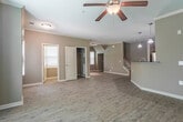 Located at 1805 Kerwyck Pl in Chesapeake, Virginia, this two-story residence offers a well-organized layout across both floors. The main level welcomes you with a bright entryway adorned with crown molding and hardwood-style flooring that extends throughout the living areas. The open-concept living and dining space is highlighted by crown molding, a ceiling fan, and pendant lighting, creating a comfortable and functional atmosphere. The kitchen is equipped with stainless steel appliances, including a refrigerator, range, and microwave, complemented by rich wood cabinetry, dark granite countertops, a breakfast bar, and a dedicated pantry for ample storage. A convenient closet is also accessible near the entryway. Upstairs, the bedrooms feature plush carpeting and natural light from well-placed windows. The primary bedroom is generously sized with multiple windows and a connected bathroom. Additional bedrooms offer closet space, making them suitable for various needs. The bathrooms are finished with wood-look tile flooring and full tub-shower combinations with brushed nickel fixtures. Throughout the home, warm neutral tones on the walls create a cohesive and inviting aesthetic, while the two-floor design provides a clear separation between living and private spaces.