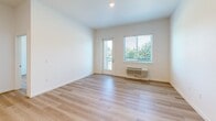 Located at 917 SW 31st St in Battle Ground, WA, this single-floor unit offers four bedrooms and two bathrooms within a well-designed, modern layout. Light wood-tone flooring runs consistently throughout the entire space, creating a bright and cohesive aesthetic.

The kitchen and living area form an open-concept hub at the heart of the unit. The kitchen is outfitted with white cabinetry, a subway tile backsplash, stainless steel appliances including a refrigerator, microwave, and range, and a central island with a quartz-style countertop that provides additional prep and gathering space. Recessed lighting illuminates the area efficiently.

The four bedrooms are generously proportioned, each featuring clean white walls and natural light from window-blind-fitted windows. Several bedrooms offer outdoor views of surrounding greenery, while one includes a wall HVAC unit and direct access to an exterior balcony. The primary bedroom features a walk-in closet with built-in shelving. One bedroom benefits from dual corner windows that bring in abundant natural light.

The two bathrooms are finished in a clean, modern style. One features a wide vanity with a quartz countertop, a large mirror, and light wood-tone flooring. The other includes a soaking tub with white subway tile surround and a grab bar for accessibility. Both bathrooms maintain the unit's bright, minimalist character.