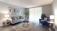 This single-floor residence offers a thoughtfully designed layout that balances comfort and functionality. The open-concept living and dining area serves as the heart of the home, featuring wood-style flooring, neutral warm-toned walls, and a textured ceiling. Large sliding glass doors and vertical blinds flood the living space with natural light, creating a welcoming and airy ambiance. The living area flows seamlessly into the dining space, making it ideal for everyday living and entertaining.

The kitchen is efficiently designed with white shaker-style cabinetry, dark countertops, and a full suite of black appliances including a range, over-the-range microwave, dishwasher, and refrigerator. A pass-through counter provides additional workspace and connects the kitchen to the main living areas.

The primary bedroom is generously sized with wood-style flooring, a large window with vertical blinds, and ample natural light. The second bedroom also features wood-style flooring and a closet with louvered bifold doors. Both bathrooms are finished consistently with cream vanity cabinetry, large mirrors, globe-style vanity lighting, and a shower-tub combination. The overall design palette throughout the residence is cohesive, clean, and move-in ready.