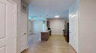 This thoughtfully designed 2-bedroom, 2-bathroom residence offers a comfortable and functional layout across a single floor. Light wood-style flooring flows throughout the main living areas and bedrooms, creating a cohesive and inviting atmosphere.

The open-concept kitchen is a central highlight, featuring dark espresso cabinetry with sleek hardware, granite-style countertops, a kitchen island, and black stainless appliances including a refrigerator, range, and microwave. The kitchen opens seamlessly into the living area, which is brightened by a ceiling fan and a glass door that invites natural light and outdoor access.

Both bedrooms are well-proportioned, each equipped with a ceiling fan, wood-style flooring, and closet storage. The primary bedroom includes a spacious walk-in closet with wire shelving systems for ample organization. The second bedroom features a double-door closet.

The two bathrooms are finished with matching dark wood vanities, granite countertops, and large mirrors. The primary bathroom is ADA-accessible, outfitted with grab bars and an open-concept vanity. Both bathrooms feature neutral tile flooring, contributing to a clean, modern aesthetic throughout.

Overall, this residence combines practical design with modern finishes, offering a comfortable and efficient living environment.