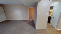 This single-story space in Abilene is designed with a practical, straightforward layout that flows naturally between its main living areas. The spacious living room features wall-to-wall carpet, warm neutral-toned walls, a textured ceiling, and a front-facing window with blinds that allows natural light to filter in. A front entry door opens directly into this area, which connects to the rest of the unit via a wood-look laminate flooring transition zone.

The kitchen is equipped with dark espresso-toned cabinetry, granite-style laminate countertops, and a full suite of black appliances including a refrigerator, electric range, and over-the-range microwave, providing a functional cooking space.

The bedrooms are carpeted and feature ceiling fans with integrated lighting, windows with blinds for natural light, and textured ceilings. The primary bedroom includes access to a walk-in closet, offering generous storage. Additional bedrooms are well-sized with their own closet access.

Two full bathrooms serve the unit, each featuring a tub and shower combination with white surround panels and chrome fixtures. One bathroom includes a vanity with a granite-style countertop and a lighted mirror. Throughout, the space maintains a consistent, neutral color palette with clean white trim and baseboards.
