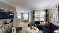 Located at 1333 Eldridge Pkwy in Houston, TX, this single-story, one-bedroom, one-bathroom residence offers a thoughtfully designed layout across a comfortable footprint. The open-concept living and dining area is bathed in natural light from large windows dressed with decorative curtains, and features crown molding that adds a refined architectural touch. The living room provides generous space for seating and entertaining, flowing seamlessly into the dedicated dining area. The kitchen is equipped with rich wood cabinetry, white appliances including a dishwasher, microwave, and range, and light tile flooring, with a pass-through counter connecting it to the main living space. The spacious primary bedroom features plush carpet, a ceiling fan, ample wall space, and a window overlooking the outdoors, creating a bright and restful retreat. A dedicated closet provides convenient storage. The bathroom is finished with white tile flooring, a large vanity with ample counter space, and a combination tub and shower accented by a distinctive green tile border. A separate laundry room houses a full-size washer and dryer along with additional shelving for storage. The residence also includes a dedicated entrance and hallway, completing a practical and comfortable floor plan.