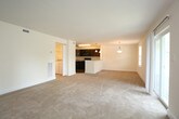Located at 4268 S Plaza Trail in Virginia Beach, Virginia, this single-floor unit offers a well-organized layout designed for comfortable everyday living. The open-concept kitchen serves as a central hub, featuring dark espresso cabinetry, granite-style countertops, black appliances including a refrigerator, range, and microwave, and a peninsula with pendant lighting overhead and an integrated sink. Wood-look flooring runs through the kitchen and extends into the bathrooms, providing a cohesive, durable finish in high-traffic areas.

The living area is generously proportioned, finished with neutral carpet, and bathed in natural light from a large window and sliding glass door that opens to a private balcony with outdoor views. The bedrooms are carpeted and well-sized, each offering natural light through slatted blinds and ample closet space, with one bedroom featuring a dual-door closet configuration. The bathroom includes dark vanity cabinetry with a light countertop, wood-look flooring, and a full tub-shower combination with tiled surround. A dedicated laundry area accommodates a full-size washer and dryer, adding everyday convenience to this practical and cohesive space.