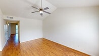 Located at 6424 Central City Blvd in Galveston, TX, this single-story 2-bedroom, 2-bathroom home offers a well-organized layout with thoughtful finishes throughout. The living room makes a strong impression with its vaulted ceiling, ceiling fan, and warm hardwood-style flooring, while a large window and glass door flood the space with natural light and provide views of the surrounding greenery. The galley-style kitchen is well-appointed with rich wood cabinetry, granite countertops, a tile backsplash, stainless steel appliances including a range, microwave, refrigerator, and dishwasher, and track lighting overhead. It flows conveniently into the adjoining dining area. The primary bedroom is generously sized, featuring vaulted ceilings, a ceiling fan, and the same hardwood-style flooring as the living areas. The second bedroom offers plush carpeting, a ceiling fan, and its own closet access. Both bathrooms are finished with granite-topped wood vanities, tile flooring, and full tub-shower combinations with white tile surrounds. Five closets throughout the home provide exceptional storage. A dedicated utility room adds further functionality to this practical and comfortable Galveston residence.