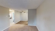 Located at 201 W California Ave in Sunnyvale, California, this single-floor unit offers a well-organized layout designed for comfortable everyday living. The open living area is finished with plush carpeting that transitions into wood-look flooring, creating a clear visual distinction between relaxation and functional zones. A ceiling fan with an integrated light fixture keeps the space comfortable year-round, while neutral gray walls and a textured ceiling give the interior a clean, understated aesthetic. A window near the entry door allows natural light to filter into the living space, enhancing the bright and airy feel throughout.

The galley-style kitchen is efficiently designed with white cabinetry, gray quartz-style countertops, and wood-look flooring. It is equipped with a full suite of stainless steel appliances, including a refrigerator, electric range, built-in microwave, and dishwasher, making it well-suited for daily cooking needs. Ample upper and lower cabinet storage ensures practical organization.

The bathroom is finished with wood-look flooring and features a full tub-and-shower combination with a brushed nickel curtain rod, a toilet, and a vanity with countertop space. The unit also includes an in-unit laundry area, adding a notable layer of everyday convenience to this Sunnyvale residence.