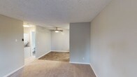 Located at 201 W California Ave in Sunnyvale, California, this single-floor unit offers a well-organized layout designed for comfortable everyday living. The open living area is finished with plush carpeting that transitions into wood-look flooring, creating a clear visual distinction between relaxation and functional zones. A ceiling fan with an integrated light fixture keeps the space comfortable year-round, while neutral gray walls and a textured ceiling give the interior a clean, understated aesthetic. A window near the entry door allows natural light to filter into the living space, enhancing the bright and airy feel throughout.

The galley-style kitchen is efficiently designed with white cabinetry, gray quartz-style countertops, and wood-look flooring. It is equipped with a full suite of stainless steel appliances, including a refrigerator, electric range, built-in microwave, and dishwasher, making it well-suited for daily cooking needs. Ample upper and lower cabinet storage ensures practical organization.

The bathroom is finished with wood-look flooring and features a full tub-and-shower combination with a brushed nickel curtain rod, a toilet, and a vanity with countertop space. The unit also includes an in-unit laundry area, adding a notable layer of everyday convenience to this Sunnyvale residence.
