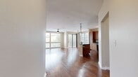 Located at 225 Town Center Lane in Keller, TX, this single-story unit offers a well-designed open-concept layout that seamlessly connects the main living areas. Rich hardwood flooring flows throughout the living and dining spaces, complemented by large windows and sliding glass doors that invite generous natural light and outdoor views.

The kitchen is thoughtfully appointed with warm honey-toned cabinetry, dark granite countertops, and a central island with a built-in sink. Three stylish cage-style pendant lights hang above the island, adding a modern touch. Black appliances, including a side-by-side refrigerator, electric range, and built-in microwave, complete the functional workspace. Track lighting above further enhances illumination throughout the cooking area.

The living room is generously proportioned, featuring a ceiling fan and a wall of windows that flood the space with natural light. Bedrooms are carpeted for comfort, each equipped with ceiling fans and ample closet space. One bedroom includes an en-suite bathroom with a combination tub and shower, a walk-in closet outfitted with wire shelving, and hardwood flooring. A secondary bedroom features a bi-fold closet. The overall ambiance is clean, modern, and move-in ready.