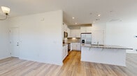 Located on Barwell Drive in Charlotte, NC, this two-story home offers a well-organized layout across two floors, with three bedrooms and three full bathrooms. The main level hosts an open-concept kitchen and living area, highlighted by light hardwood-style flooring, recessed lighting, and a clean, neutral color palette. The kitchen is equipped with white shaker cabinetry, granite countertops, stainless steel appliances including a French door refrigerator and range, a tile backsplash, and a central island with a sink — ideal for both meal prep and casual dining. The living area flows naturally from the kitchen, featuring large windows that invite natural light and neighborhood views. An attached garage with an automatic door opener and a dedicated utility room add practical convenience on the ground floor. Upstairs, the three bedrooms are carpeted for comfort, each with access to natural light through well-placed windows. The spacious primary bedroom includes a closet and direct access to a bathroom. Additional bedrooms share a full bathroom featuring a tub-shower combination, white vanity, and wood-look tile flooring. A second staircase configuration enhances the home's functional flow. The exterior includes a concrete driveway and landscaped grounds.