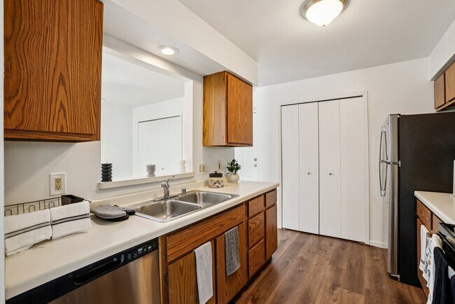 Well-appointed kitchens offer wood cabinetry and stainless steel dishwashers for modern convenience, professionally operated by Highlands Vista Group. - Madison Estates