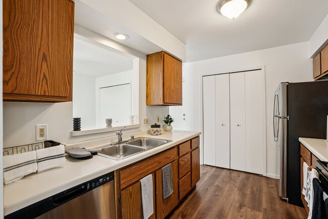 Well-appointed kitchens offer wood cabinetry and stainless steel dishwashers for modern convenience, professionally operated by Highlands Vista Group. - Madison Estates