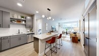 This thoughtfully designed 2-bedroom, 2-bathroom residence in Milwaukee, WI offers a modern open-concept layout with stylish finishes throughout. The combined kitchen and living area serves as the heart of the home, anchored by a large center island with seating, sleek gray cabinetry, stainless steel appliances, and a contemporary multi-globe pendant light. Light wood-style flooring runs throughout the main living spaces, complementing the neutral color palette. The living room is bright and welcoming, featuring large windows that invite abundant natural light and offer outdoor views. The spacious primary bedroom includes plush carpeting, large windows, and generous closet space. A second well-proportioned bedroom provides flexibility for guests or a home office. The primary bathroom features a glass-enclosed walk-in shower with white subway tile, a gray vanity with a white countertop, and matte black fixtures. The second bathroom offers a full tub-shower combination with similarly refined finishes. Four closets provide ample storage throughout the unit. Additional conveniences include an in-unit laundry area and a private patio, rounding out a well-appointed residence designed for comfortable everyday living.