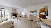Located at 711 Lake Harbour Dr in Ridgeland, Mississippi, this single-floor residence offers 2 bedrooms and 2 bathrooms within a well-organized layout. The living room serves as the heart of the home, highlighted by a classic brick wood-burning fireplace and sliding glass doors that open to a private outdoor deck, filling the space with natural light and providing easy outdoor access. Soft carpet underfoot and a textured ceiling complete the warm, comfortable ambiance of this central gathering area, which flows naturally into a dedicated dining space.

The kitchen features warm oak cabinetry, light countertops, and black appliances including a dishwasher and refrigerator, complemented by hardwood-style flooring for easy maintenance. A louvered-door closet adds convenient storage nearby.

The primary bedroom is generously proportioned, offering carpet flooring, a ceiling fan, and a walk-in closet. The second bedroom is equally comfortable, also carpeted and ceiling fan-equipped with a bright window. Both bathrooms mirror each other in style, each featuring wood-toned vanity cabinetry, light stone-finish countertops, a large mirror, and hardwood-style flooring. Two additional closets throughout the unit provide ample storage, rounding out this practical and inviting Ridgeland residence.