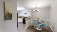 Located at 630 Bell Rd in Nashville, TN, this single-floor, one-bedroom, one-bathroom residence offers a thoughtfully arranged layout that maximizes its comfortable footprint. The living room serves as the heart of the home, featuring dark hardwood-style flooring, a tile-surround fireplace, and a sliding glass door that fills the space with natural light and provides access to an outdoor area. Adjacent to the living room, the dedicated dining area is defined by an elegant chandelier overhead and continues the warm, cohesive aesthetic throughout. The kitchen is well-appointed with crisp white cabinetry, granite-style countertops, black appliances including a range and refrigerator, and a peninsula that connects the cooking space to the dining area. The bedroom offers plush carpeting, a vaulted ceiling, and its own sliding glass door leading to an outdoor balcony, creating a bright and airy retreat. A hallway connects the main living areas to the bedroom, closet, and bathroom. The bathroom features a white vanity with a granite-style countertop, a large mirror, and wood-style flooring. Neutral gray walls and consistent finishes throughout create a clean, modern ambiance suited for comfortable everyday living in Nashville.