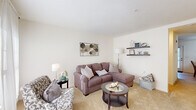 Located at 502 W River Rd in Hooksett, NH, this multi-floor residence offers 2 bedrooms and 3 bathrooms thoughtfully distributed across three levels. The main living area features a bright, carpeted living room filled with natural light from large windows dressed in sheer curtains, creating a warm and inviting atmosphere. Decorative floating shelves add a personalized touch to the neutral-toned walls. Adjacent to the living room, the dining area accommodates a full dining table and benefits from its own window, maintaining a light and airy feel. The kitchen is equipped with warm oak cabinetry, stainless steel appliances including a refrigerator and dishwasher, and tile flooring. A door with a large window provides additional natural light and outdoor access. The primary bedroom is a comfortable retreat featuring plush carpeting, multiple windows with sheer draping, and ample space for furnishings. A dedicated closet adds practical storage. The additional bedroom is equally well-appointed. Three bathrooms serve the home, including one with a shower-tub combination and tile flooring with a wood-toned vanity. A utility room and multiple staircases connect the floors efficiently. Throughout, the home maintains a clean, neutral palette that creates a cohesive and welcoming environment.
