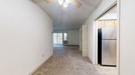 Located at 2055 Seventh Ave E in North St. Paul, MN, this three-bedroom, one-bathroom unit offers a practical and comfortable single-floor layout. The living area is bright and open, featuring plush carpet flooring, a ceiling fan with light fixture, and sliding glass doors that lead to a private balcony with wooded views. Natural light flows generously through multiple windows, creating a welcoming atmosphere throughout.

The kitchen is well-appointed with warm maple cabinetry, granite-patterned countertops, tile flooring, and stainless steel appliances including a refrigerator, electric range, and dishwasher — providing ample storage and workspace for everyday cooking.

The generously sized primary bedroom offers abundant space and includes dual closets with louvered bifold doors, carpeted flooring, a ceiling fan, and baseboard heating. The additional bedrooms are also carpeted and feature ceiling fans and windows overlooking the surrounding greenery. Each room is finished with clean white walls and neutral tones throughout.

The bathroom features mosaic tile flooring, a tiled tub/shower surround, and a vanity with countertop. A connecting hallway and two closets provide additional storage. Baseboard heating is present throughout the unit, ensuring consistent comfort year-round.