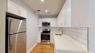 Located at 5959 Broadway in the Riverdale neighborhood of the Bronx, Unit 406 is a well-appointed residence that has been tastefully renovated with modern finishes throughout. The kitchen is a standout feature, showcasing crisp white shaker cabinetry, gleaming quartz countertops, a classic white subway tile backsplash, and stainless steel appliances including a range, over-the-range microwave, and refrigerator. A stainless steel undermount sink with a sleek arc faucet completes the space, all set atop warm hardwood flooring. The living and bedroom areas are finished with the same rich hardwood floors, offering a cohesive and inviting feel. Recessed lighting and large windows allow for natural light to fill the rooms, while a baseboard heating unit ensures comfort year-round. Bedrooms feature closet space with built-in hanging rods. The bathroom is elegantly finished with white subway tile walls, marble-look tile flooring, a white vanity with a mirrored medicine cabinet, and modern brushed nickel fixtures. Clean lines and a neutral palette are maintained throughout, creating a bright, move-in-ready home with a contemporary aesthetic.