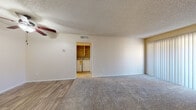 This single-floor residence offers a thoughtfully laid-out living space with a clean, neutral aesthetic throughout. The open living area is anchored by wood-look hard flooring that transitions seamlessly into plush carpeting, creating distinct zones for relaxing and entertaining. A ceiling fan with light fixture provides both comfort and illumination, while large sliding glass doors with vertical blinds invite abundant natural light and lead to a private outdoor balcony or patio with lattice detailing.

The kitchen is efficiently designed with white cabinetry, light stone-look countertops, a double stainless steel sink, a dishwasher, and an electric range, all complemented by a window that brings in additional natural light. A dedicated laundry area with built-in shelving accommodates a full-size washer and dryer, adding everyday convenience.

The bedroom is generously sized, finished with soft carpeting and textured ceilings, and features a large walk-in closet with built-in shelving for ample storage. A window provides natural light and outdoor views. The full bathroom is outfitted with white vanity cabinetry, a stone-look countertop, a framed mirror, wood-look flooring, and a full tub-shower combination. Throughout the residence, a consistent warm and neutral color palette creates a bright, inviting ambiance.