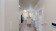 Located at 59 Summerlake Cir in Ridgeland, SC, this single-floor, 2-bedroom, 2-bathroom home offers a well-organized layout across a comfortable footprint. The kitchen is efficiently designed with warm wood cabinetry, light countertops, black appliances including a refrigerator, electric range, microwave, and dishwasher, and durable hardwood-style flooring. A door off the kitchen leads to a dedicated laundry area equipped with a washer and overhead wire shelving for additional storage. The living area features crown molding, a ceiling fan, hardwood-style flooring, and sliding glass doors that open to a private balcony overlooking lush greenery, filling the space with natural light. Both bedrooms are carpeted and include ceiling fans and windows with blinds that allow for ample natural light. The primary bedroom offers a generous layout. Two hallways connect the rooms and provide access to two dedicated closets. Both bathrooms are finished with wood-vanity cabinetry, light countertops, mirrors, tub-shower combinations with curtains, and hardwood-style flooring. The home maintains a neutral, warm color palette throughout, creating a cohesive and inviting atmosphere well-suited for comfortable everyday living.