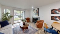 Located in Kent, WA, this thoughtfully updated 2-bedroom, 2-bathroom single-floor residence offers a clean, modern aesthetic with warm, inviting touches throughout. The living room serves as the heart of the home, featuring light wood-look flooring, a tile-surround fireplace, and a sliding glass door that opens to an outdoor view, filling the space with natural light. A second seating area provides additional room for relaxation or casual dining.

The kitchen is a standout, showcasing crisp white shaker cabinets with matte black hardware, stone countertops, black appliances, and a skylight that brightens the galley-style layout. Wood-look flooring continues seamlessly underfoot.

The primary bedroom offers plush carpeting, a window with outdoor views, a walk-in closet with built-in shelving, and a well-lit, comfortable atmosphere. The second bedroom is equally inviting, with carpeted floors, natural light, and a sliding-door closet. Both bathrooms are finished in clean white palettes, each featuring a full tub-shower combination — one with modern black fixtures and wood-look flooring, and the other with classic chrome finishes. A hallway connects the rooms efficiently, completing this well-organized and move-in-ready residence.
