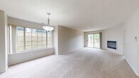 This renovated 2-bedroom, 2-bathroom Shire floor plan offers a thoughtfully designed single-level layout with a bright, open ambiance throughout. The generously sized living and dining area is a standout feature, showcasing plush neutral carpeting, a cozy fireplace, and an abundance of natural light streaming through large picture windows and sliding glass doors that open to outdoor views of lush greenery. A pendant light fixture adds a refined touch to the space.

The kitchen has been updated with rich dark cabinetry, crisp white countertops, wood-look flooring, and stainless steel appliances including a range, built-in microwave, and dishwasher — offering a functional and stylish cooking space.

Both bedrooms are well-proportioned, each featuring soft carpeting and large windows that invite natural light and views of the surrounding landscape. The bedrooms provide a calm, restful atmosphere with easy access to the shared living spaces.

The two bathrooms are finished with wood-look flooring, dark vanity cabinetry, white countertops, and full tub-shower combinations. Clean lines and updated fixtures give each bathroom a polished, contemporary feel. Together, the rooms create a cohesive, move-in-ready home with a neutral palette and modern renovations throughout.